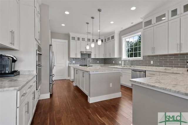 kitchen with dark wood-style floors, stainless steel appliances, tasteful backsplash, and white cabinets