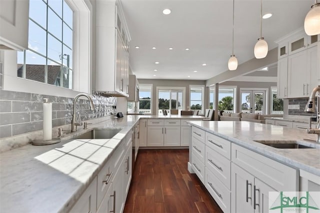 kitchen with plenty of natural light, a sink, glass insert cabinets, and white cabinetry