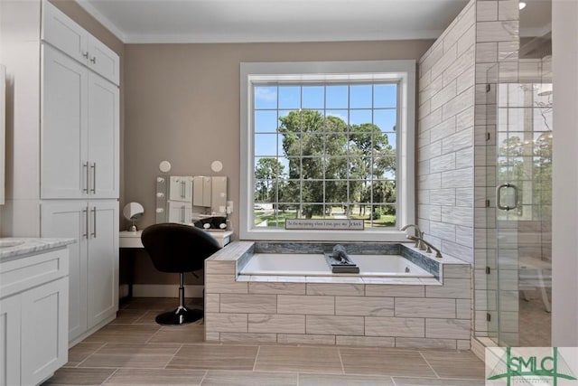 full bathroom featuring a garden tub, plenty of natural light, a shower stall, and vanity