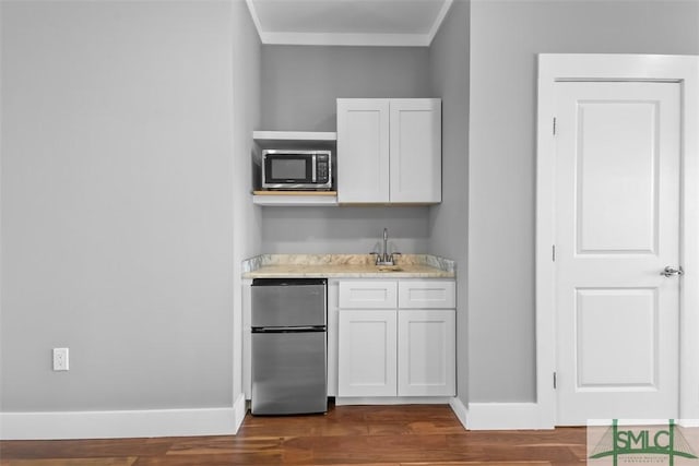 kitchen with baseboards, dark wood-style floors, stainless steel appliances, light countertops, and white cabinetry