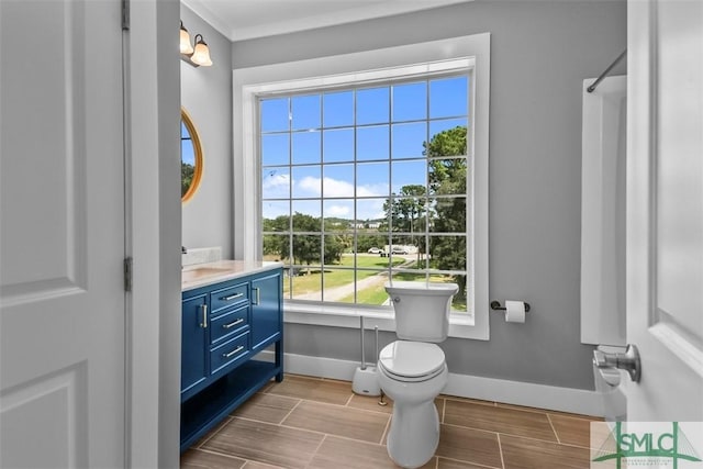 full bath featuring toilet, baseboards, wood finish floors, and vanity