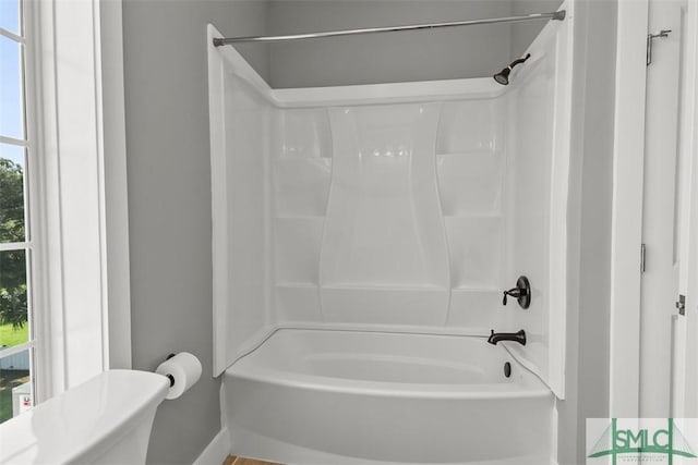 bathroom featuring tub / shower combination and toilet