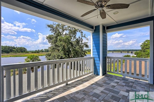 balcony featuring ceiling fan and a water view