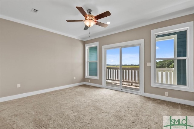 spare room with carpet flooring, ceiling fan, visible vents, and baseboards