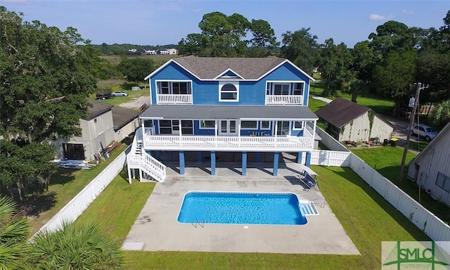 rear view of property with a patio, a lawn, a fenced backyard, and a balcony