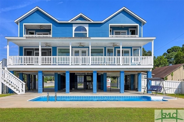 back of house with ceiling fan, a patio, fence, and a balcony