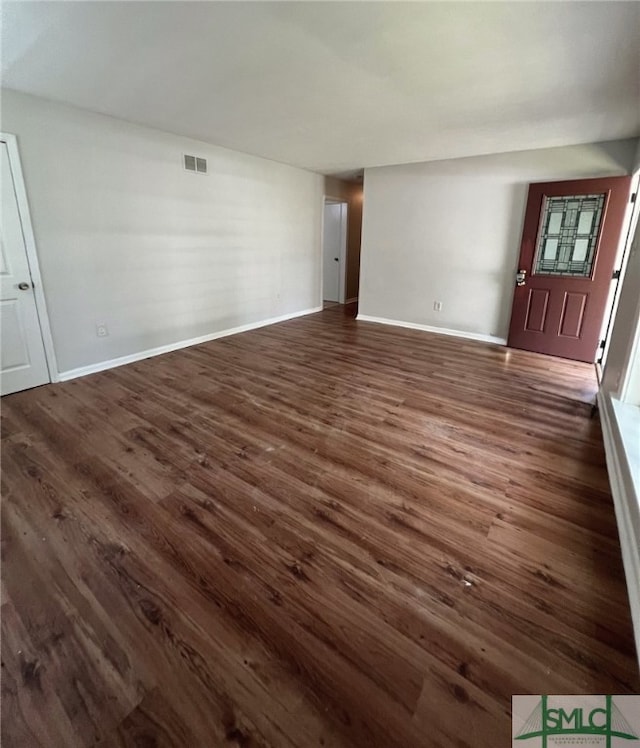 unfurnished living room featuring dark wood-type flooring