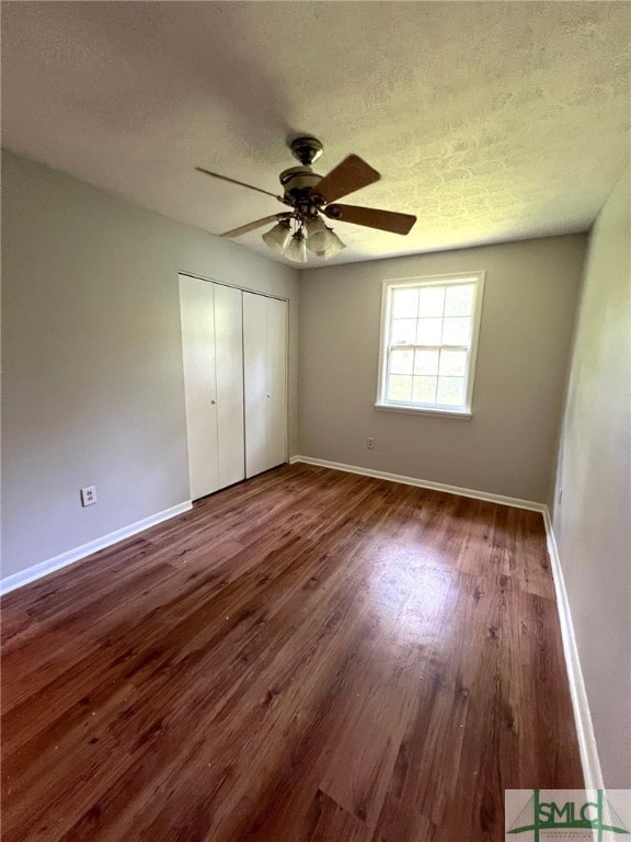 unfurnished bedroom featuring ceiling fan, hardwood / wood-style flooring, and a closet