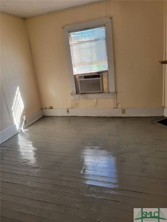 spare room with hardwood / wood-style flooring and cooling unit