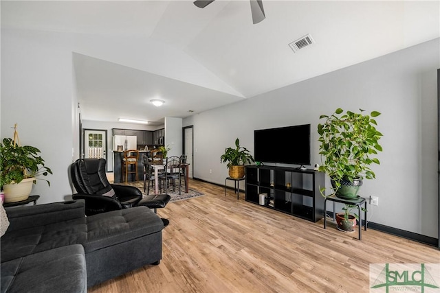 living room with lofted ceiling, light hardwood / wood-style floors, and ceiling fan