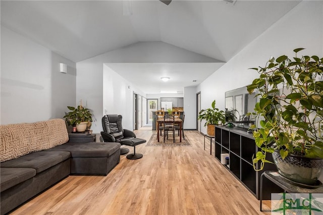 living room featuring vaulted ceiling and light wood-type flooring