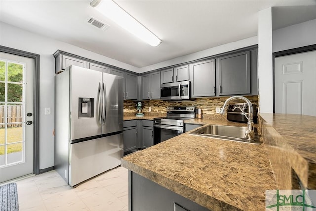 kitchen featuring stainless steel appliances, gray cabinets, and sink