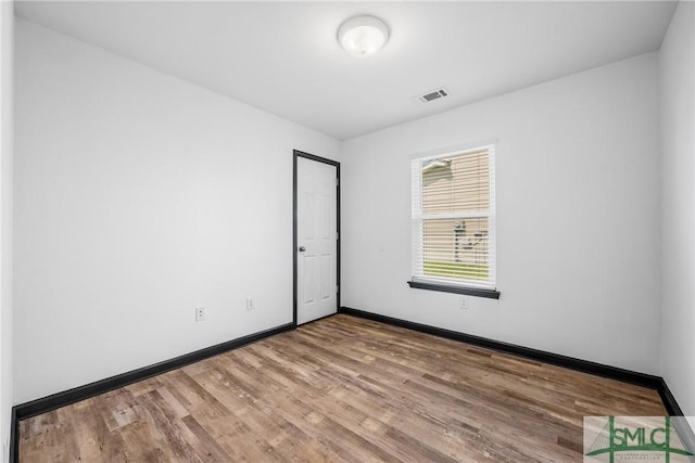 unfurnished room with wood-type flooring