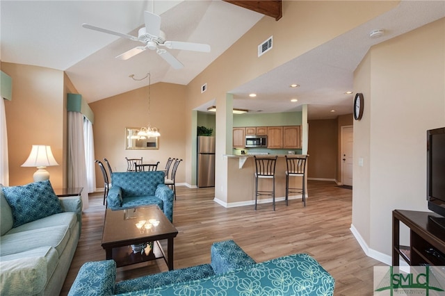 living room with high vaulted ceiling, ceiling fan with notable chandelier, beamed ceiling, and light hardwood / wood-style floors