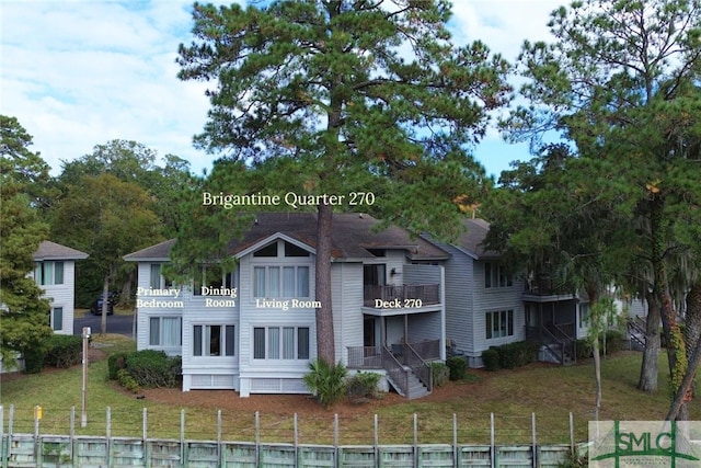 rear view of house featuring a balcony and a lawn