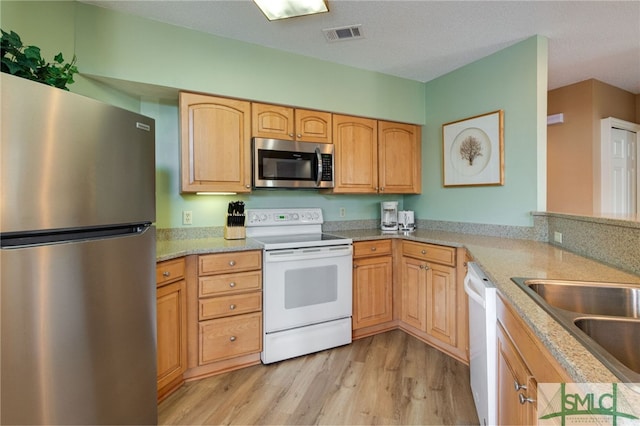 kitchen featuring light wood-type flooring, stainless steel appliances, and light brown cabinets