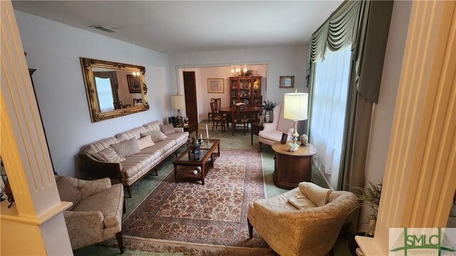 carpeted living room featuring a chandelier