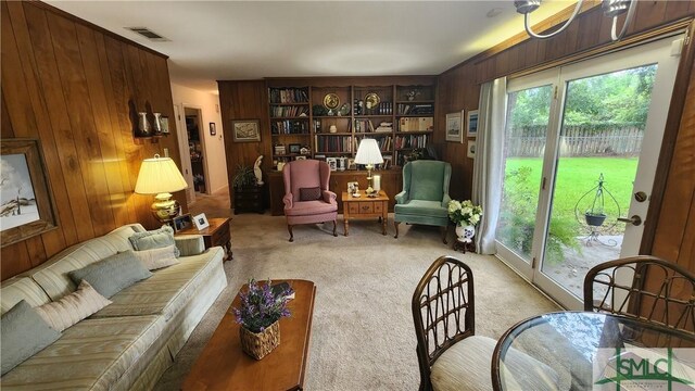 living room featuring light carpet and wooden walls