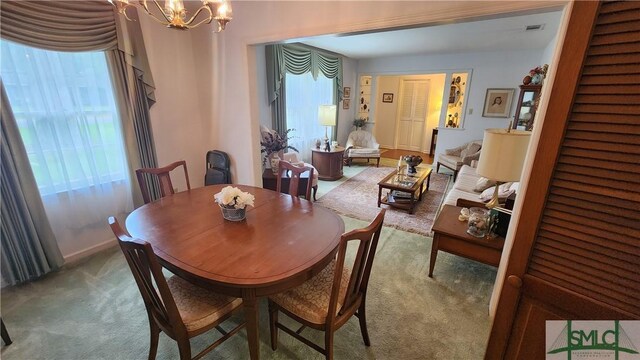 dining space featuring a notable chandelier and carpet floors