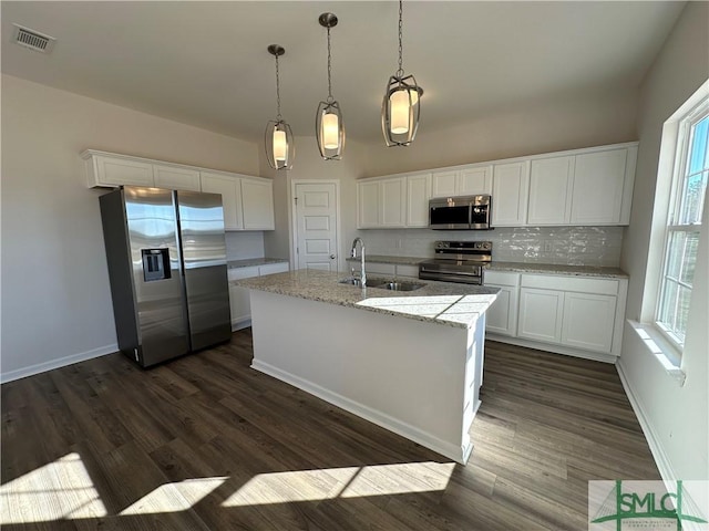 kitchen featuring sink, stainless steel appliances, pendant lighting, a kitchen island with sink, and white cabinets