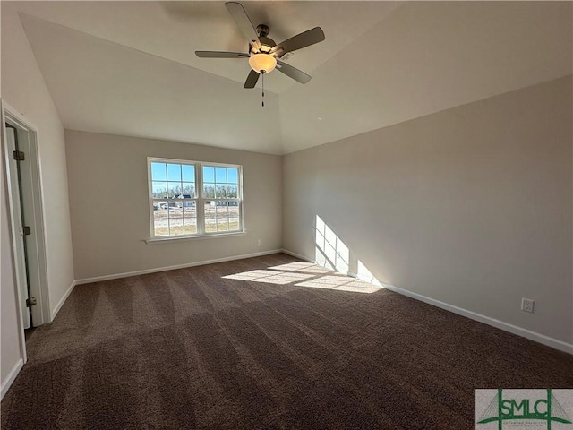 empty room featuring dark carpet, vaulted ceiling, and ceiling fan