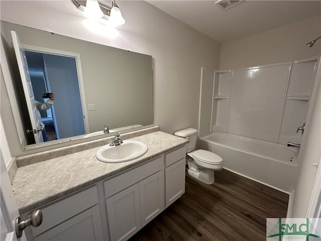 full bathroom with washtub / shower combination, vanity, hardwood / wood-style flooring, and toilet