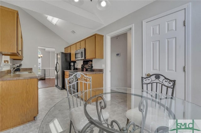 kitchen featuring sink, high vaulted ceiling, and appliances with stainless steel finishes