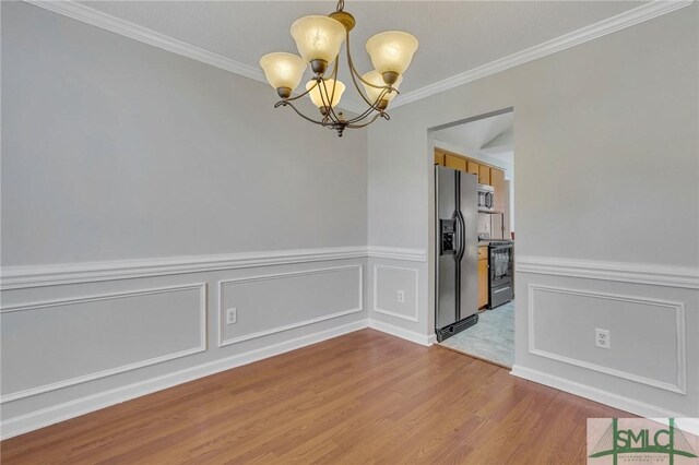 unfurnished dining area featuring an inviting chandelier, ornamental molding, and wood-type flooring