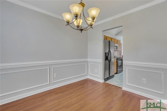 unfurnished room with crown molding, hardwood / wood-style floors, and a notable chandelier