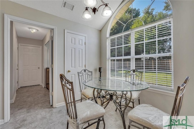 dining area featuring lofted ceiling and a notable chandelier