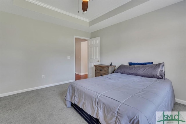 bedroom with a tray ceiling, carpet floors, ornamental molding, and ceiling fan