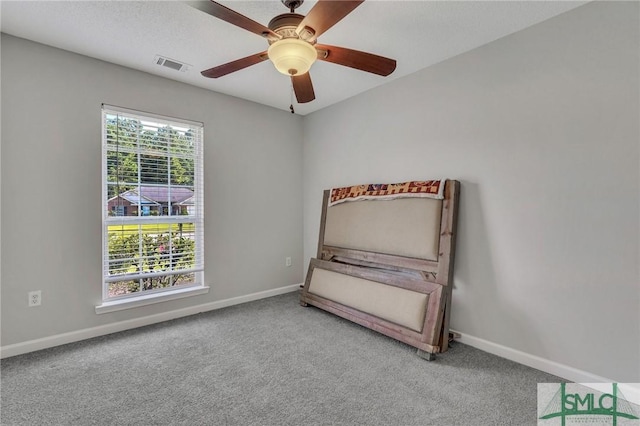 unfurnished bedroom featuring ceiling fan, light colored carpet, and a textured ceiling