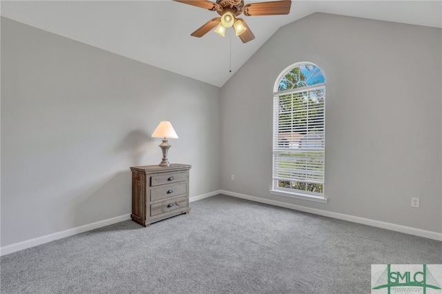 carpeted spare room with ceiling fan and vaulted ceiling