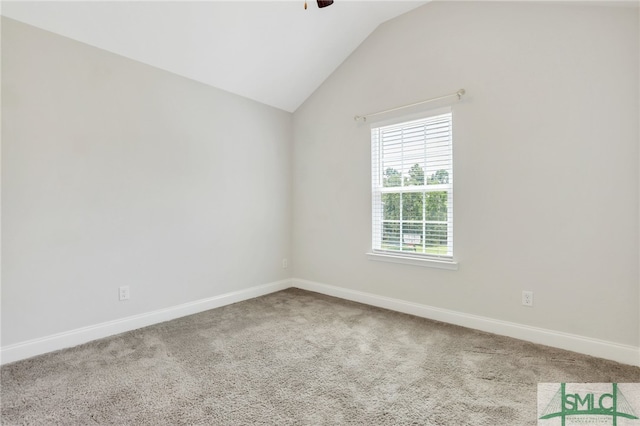 carpeted empty room with vaulted ceiling