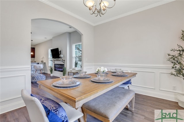 dining area with a notable chandelier, dark wood-type flooring, and crown molding