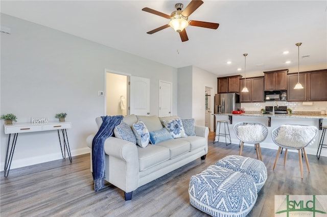 living room with ceiling fan and hardwood / wood-style flooring