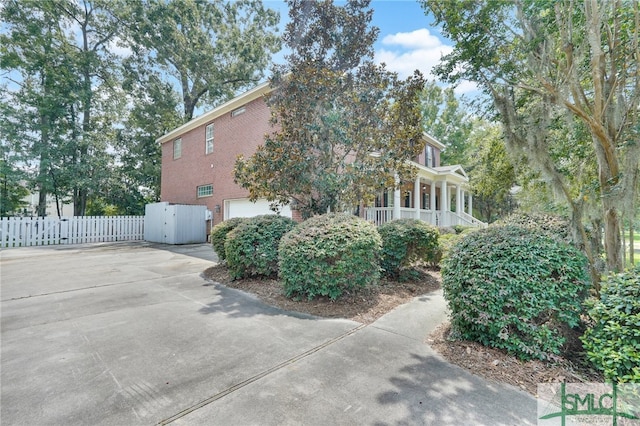 view of side of home featuring covered porch and a garage