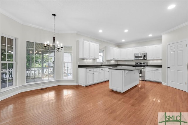 kitchen featuring an inviting chandelier, decorative light fixtures, light hardwood / wood-style floors, stainless steel appliances, and white cabinets