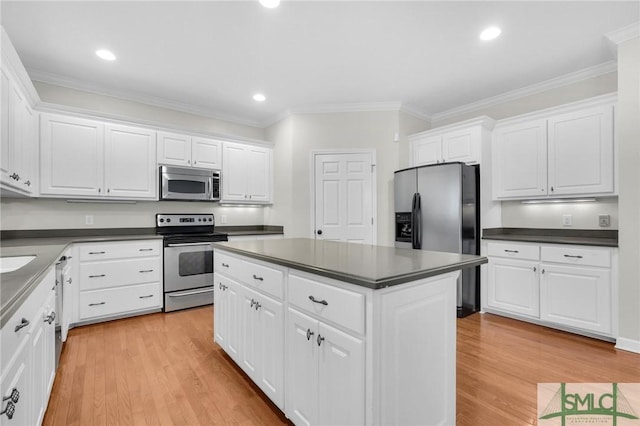 kitchen with appliances with stainless steel finishes, light hardwood / wood-style flooring, and white cabinets