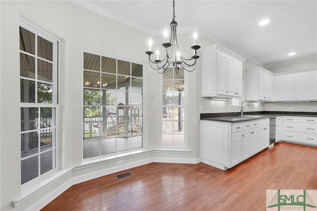 kitchen with white cabinetry, light hardwood / wood-style flooring, a chandelier, and decorative light fixtures