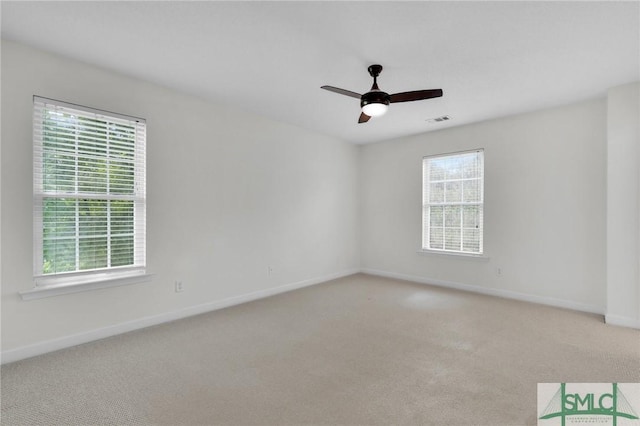 carpeted empty room with a wealth of natural light and ceiling fan