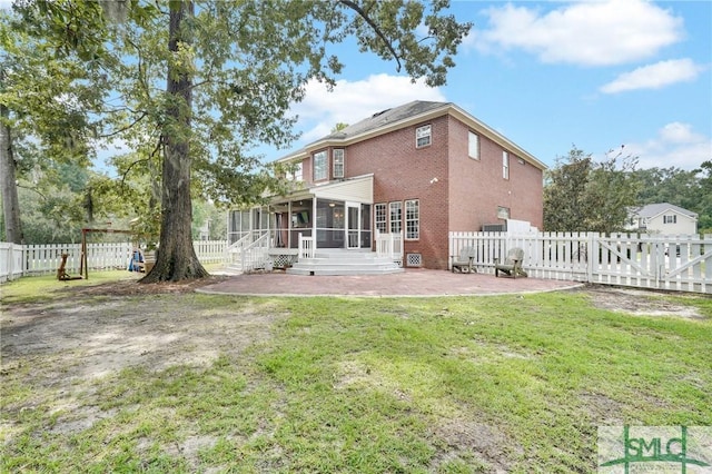 back of house featuring a yard, a patio area, and a sunroom