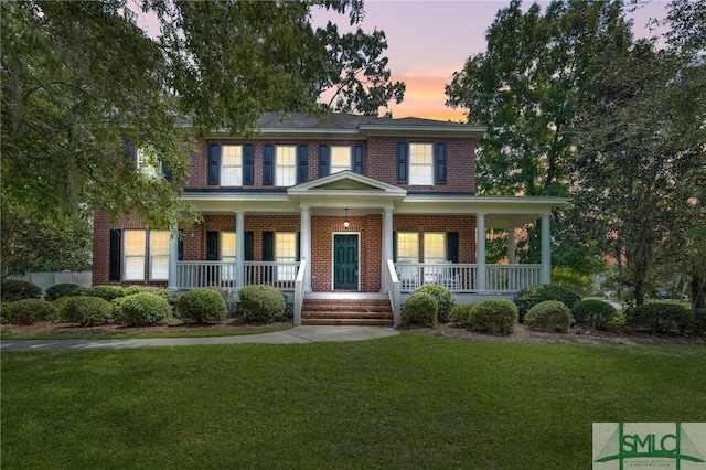 view of front of home with a porch and a yard