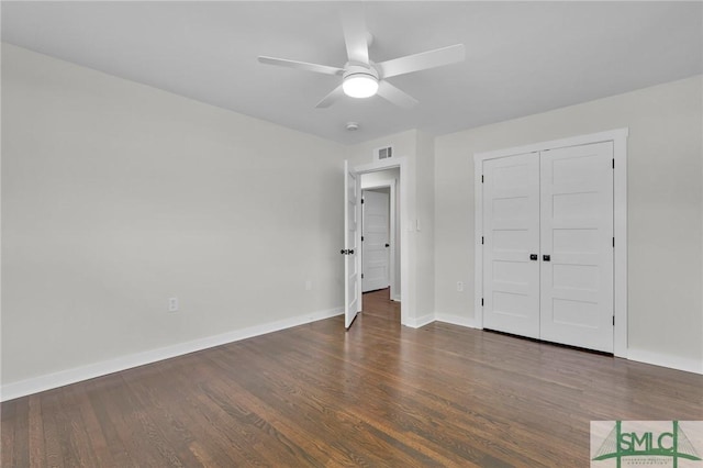 unfurnished bedroom featuring dark wood-type flooring, a closet, and ceiling fan