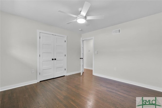 unfurnished bedroom featuring dark hardwood / wood-style floors, ceiling fan, and a closet