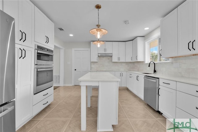 kitchen featuring light tile patterned flooring, pendant lighting, white cabinetry, sink, and stainless steel appliances