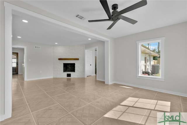 unfurnished living room featuring light tile patterned floors, a large fireplace, and ceiling fan