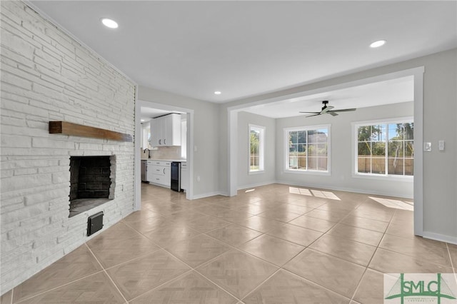 unfurnished living room with light tile patterned flooring, ceiling fan, and a stone fireplace