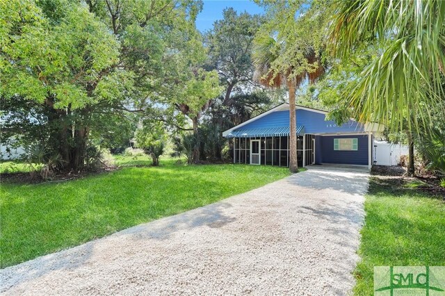 view of front of property featuring gravel driveway and a front lawn