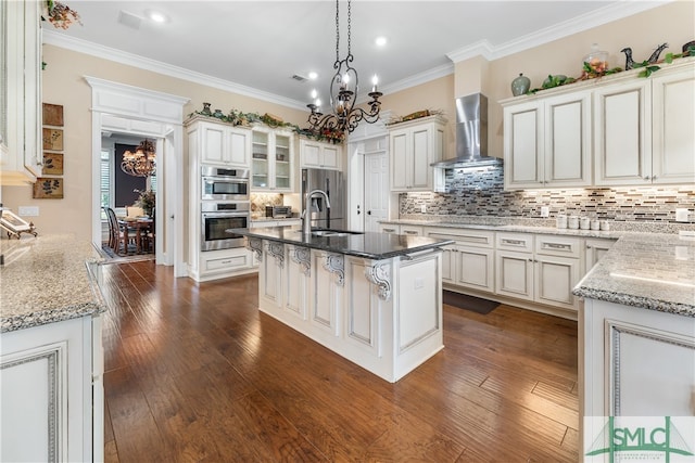 kitchen with stainless steel appliances, dark hardwood / wood-style flooring, a center island with sink, and wall chimney range hood